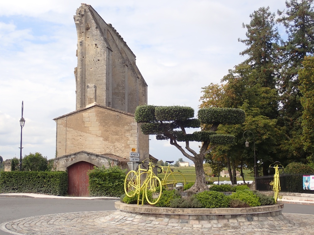 Stone building with trees and bike sculpture
